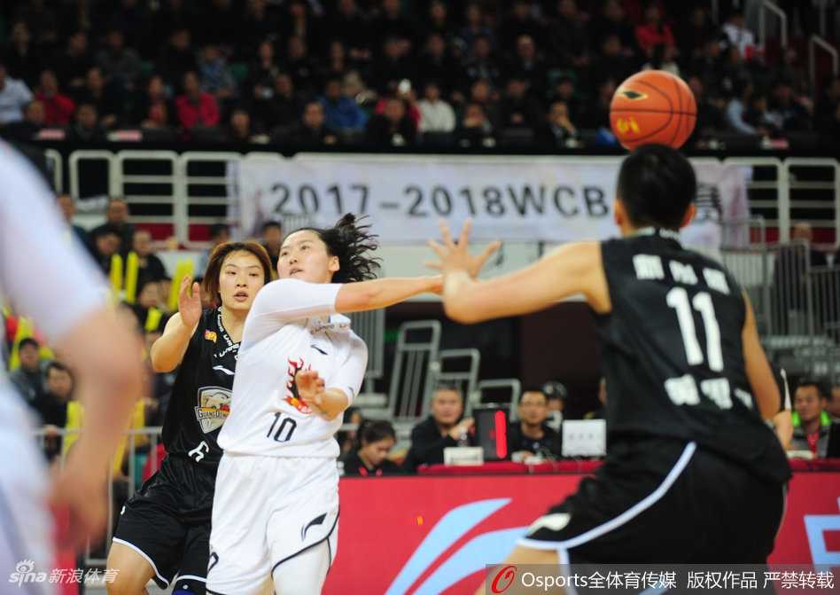 广东女篮核心杨力维运球组织进攻，她眼神坚定试图加速摆脱山西队防守球员，但山西队的防守阵型保持得极为严密