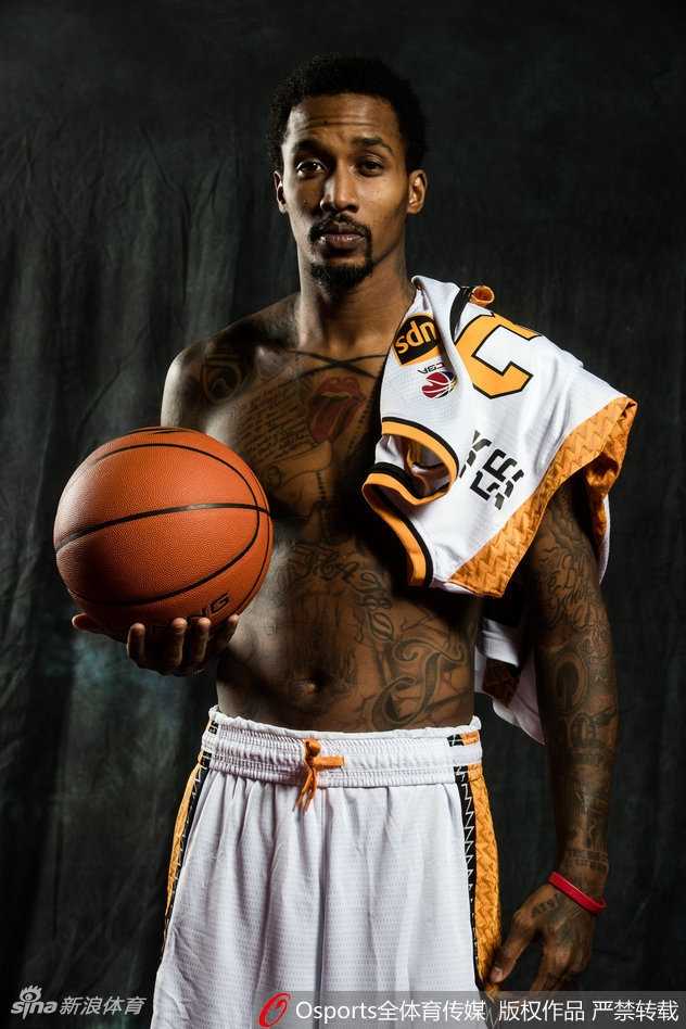 山西男篮教练组与队员们一起拍摄大合影，大家紧密地靠在一起，对着镜头露出灿烂的笑容，教练也比出大拇指，背景是球队新赛季的官方背景板，气氛融洽。