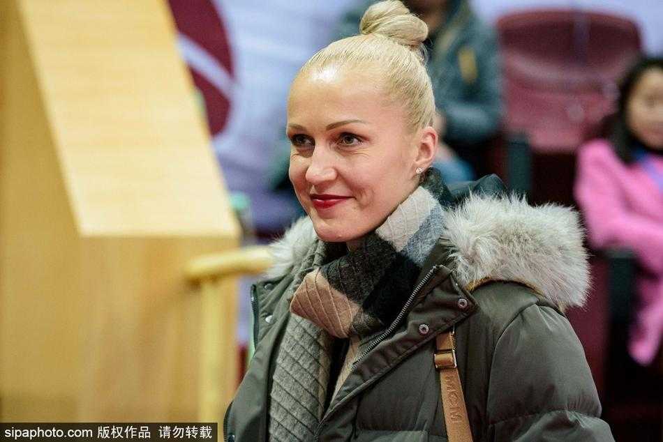 比赛尘埃落定，四川女篮外援起身准备离场，脸上带着满意的神情。她们身后的记分牌显示着四川队122比105的胜利比分，仿佛在诉说一场精彩的跨界助威故事。