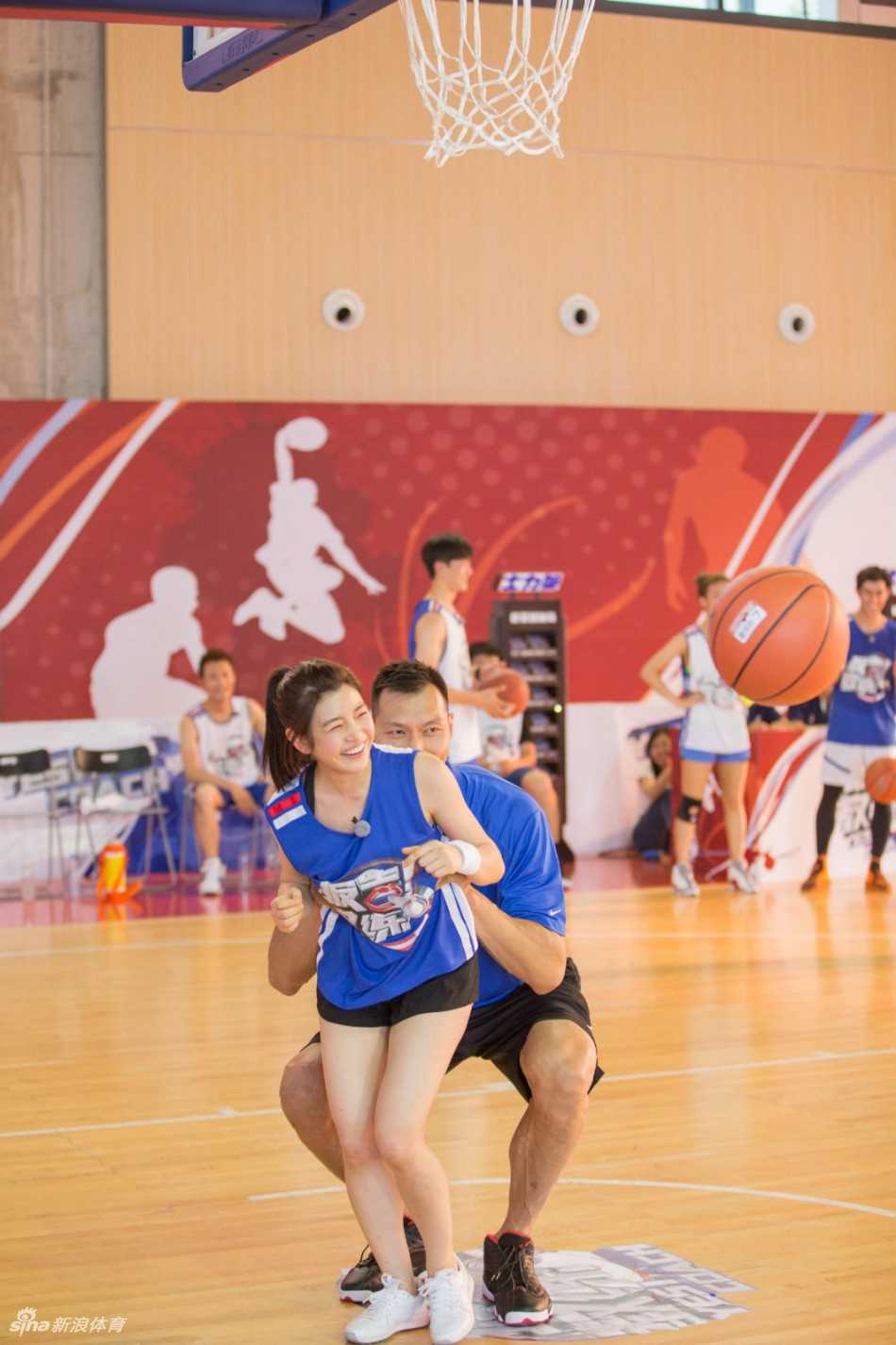 易建联轻松将陈妍希托举至篮筐前，两人的身高差形成一道独特的风景线