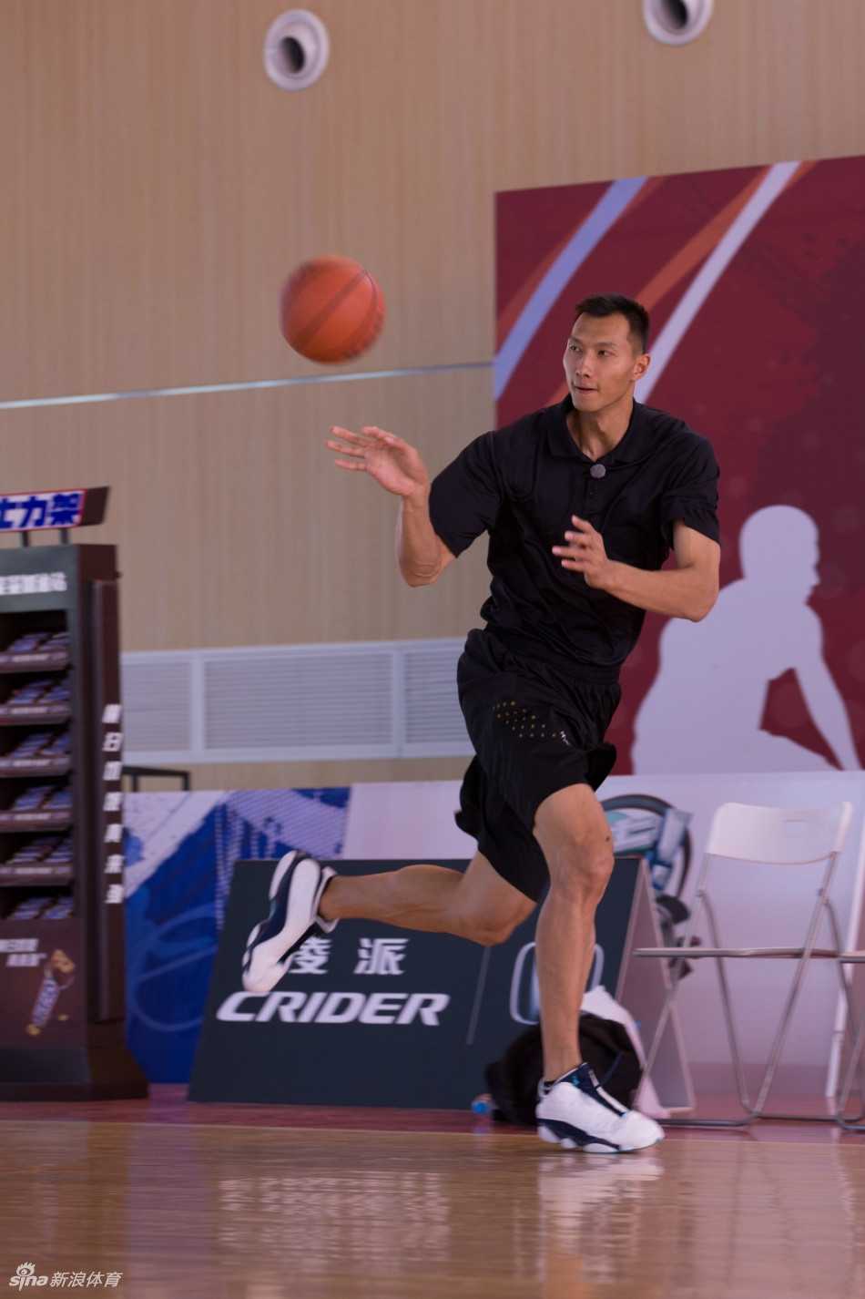 易建联双手托举陈妍希望向篮筐，陈妍希准备将球放入，画面充满动态美感