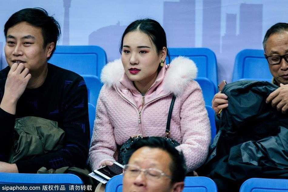 镜头下，这位被捕捉到的美女球迷似乎刚刚发现被拍摄，眼神中流露出一丝不经意的茫然，在周围深色衣着的球迷映衬下，她宛如一朵绽放的清新百合。