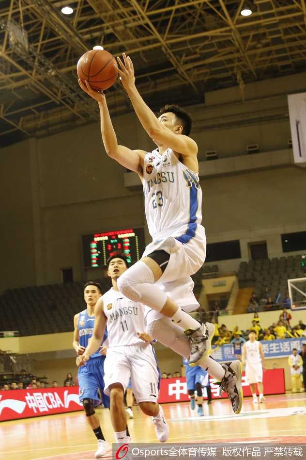 江苏队的防守悍将史鸿飞目光如炬，他紧紧贴防青岛队的持球队员，双臂张开形成一道难以逾越的屏障，展现不屈的防守态度。