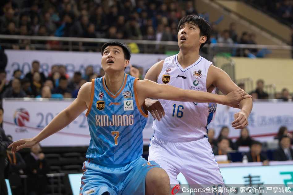 江苏队外援马尚·布鲁克斯面对新疆队员可兰白克的贴身防守，灵活地运球变向，眼神中充满自信与坚定，准备随时启动突破防线。