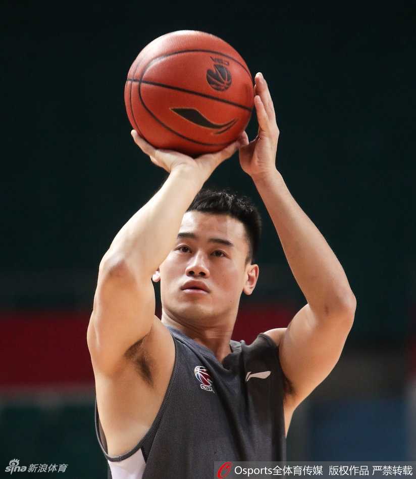 主教练手持战术板，正在为球员范子铭讲解防守站位细节，两人表情严肃，交流战术心得。