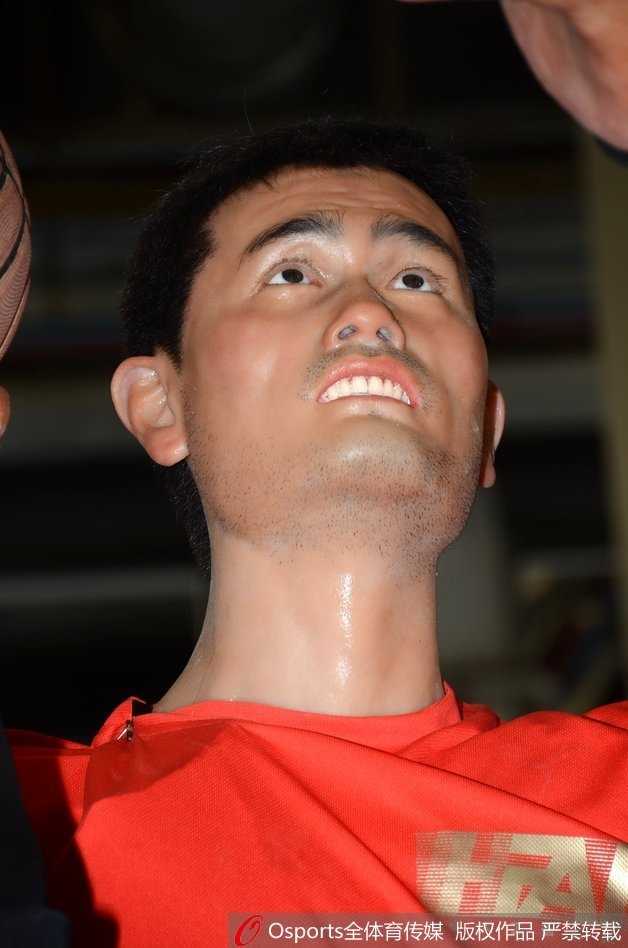 从背后仰望，机器人的身形与真人无异，宽阔的肩膀和修长的手臂在展馆灯光下投下长长的影子，宛如一位守护篮下禁区的真正巨人。