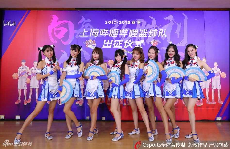 身着水手服的啦啦队员在球场上活力四射，她们的青春气息与身后巨大的漫画版球队海报相映成趣，仿佛从二次元世界穿越而来的篮球应援团。