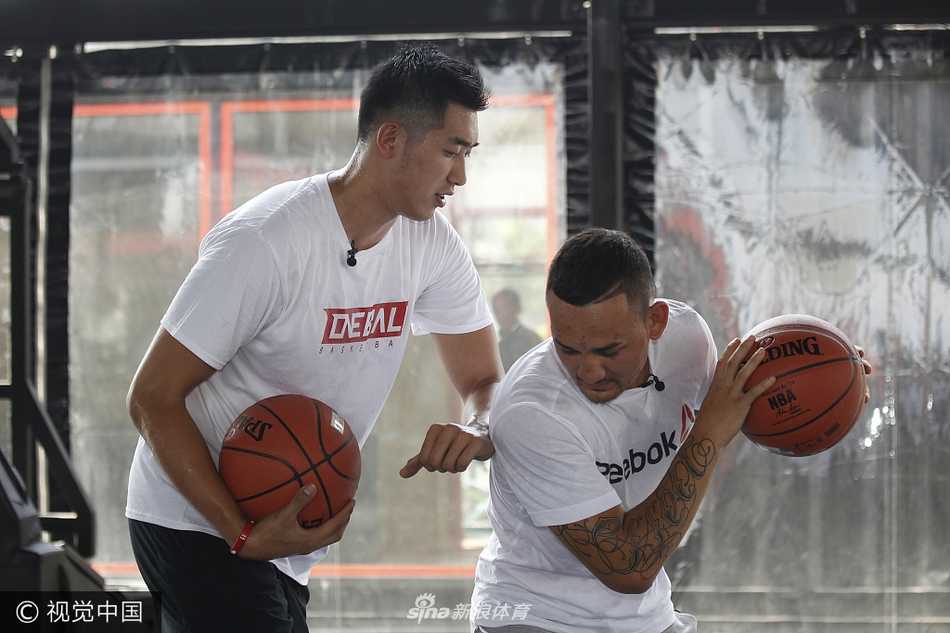 夏日上海的高温下，UFC羽量级冠军霍洛威（左）与CBA悍将吴冠希（右）在篮球场上同框亮相，霍洛威的拳击手身材与吴冠希的挺拔身高形成鲜明对比，两人对着镜头露出轻松的笑容。