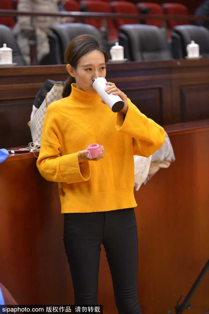 嘈杂的球馆内，她静静凝视着取景器，脸颊在闪光灯的映照下泛着微光。即便身边人声鼎沸，她眼中只有赛场的瞬息万变，那份静若处子的专注令人过目难忘。