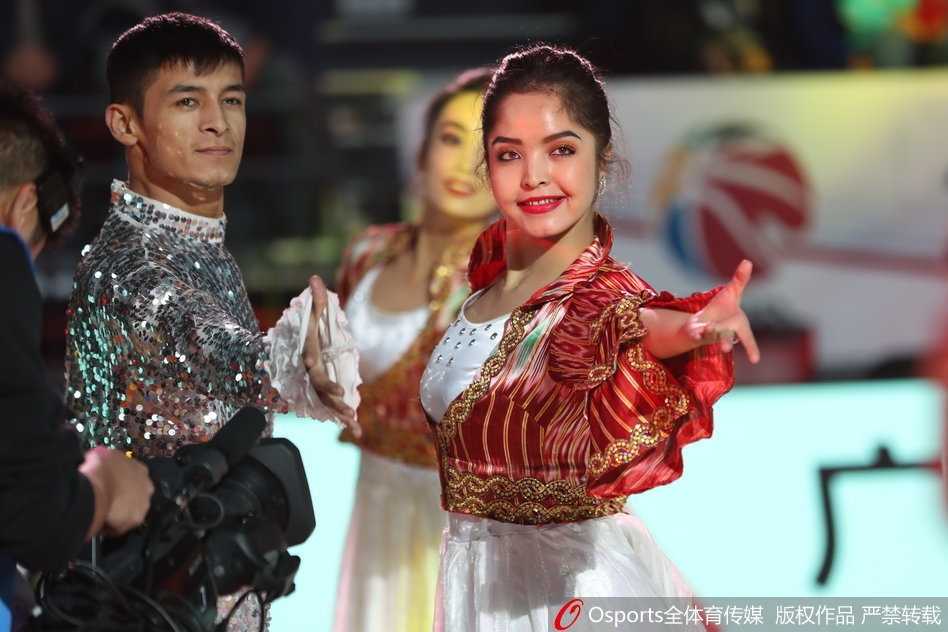 新疆主场惊现西域风华 异域之美点燃冬日激情 主场内,一位气质冷艳的西域美女回眸凝视,她的侧颜线条优美,长长的睫毛在灯光下投下阴影,身后的观众席虚化成一片热闹的背景。