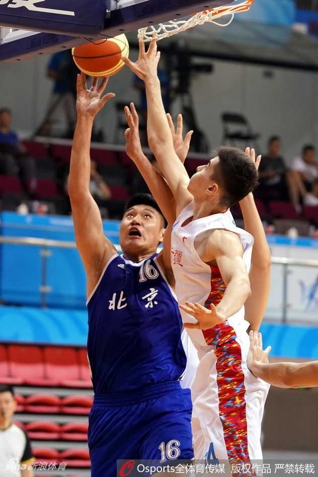 新疆广汇破釜沉舟击退北京首钢,全运会创历史首闯四强 新疆球员俞长栋在篮下遭遇三人包夹,他咬紧牙关强行起篮,肌肉线条在对抗中清晰可见,展现了极强的内线统治力。