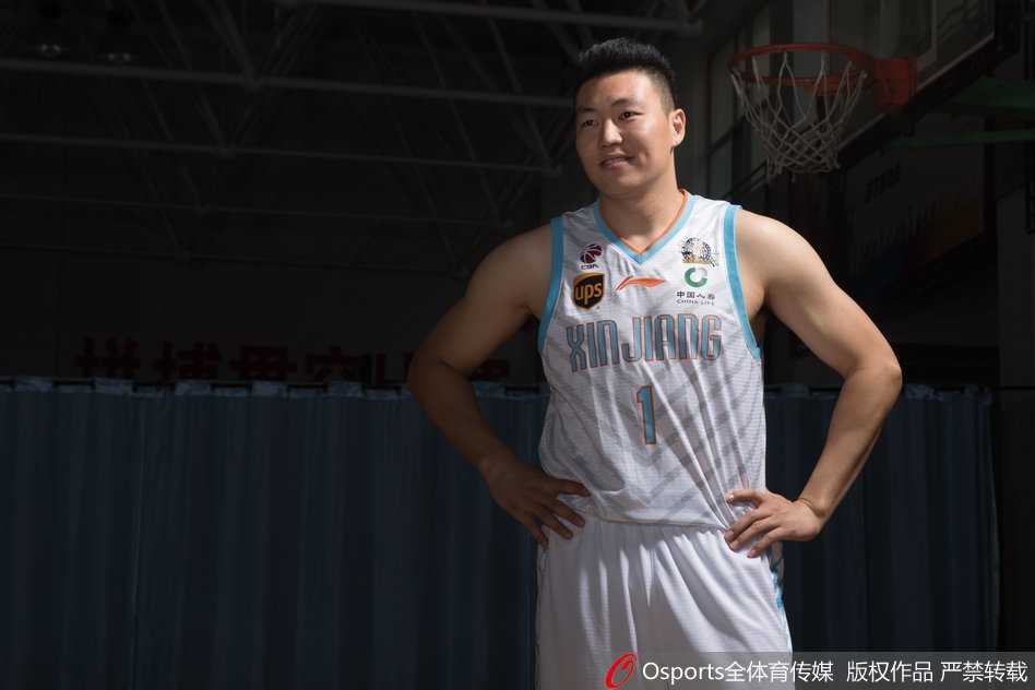 新疆广汇飞虎男篮新赛季写真定格卫冕之路的自信与锋芒 可兰白克-马坎身披新疆队战袍,双手叉腰站立,目光如炬凝视前方,队长袖标在灯光下熠熠生辉,仿佛在无声宣告着守护球队荣誉的誓言。