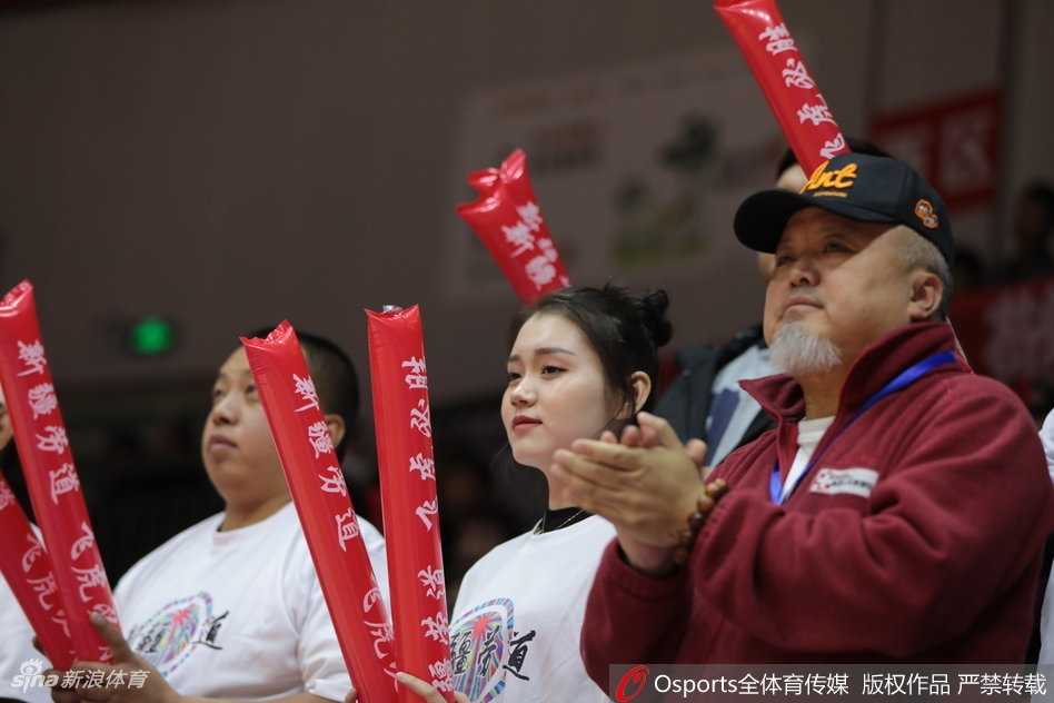 一位颜值出众的新疆美女球迷，目光专注地望向赛场方向，眼神中充满了对比赛的期待。