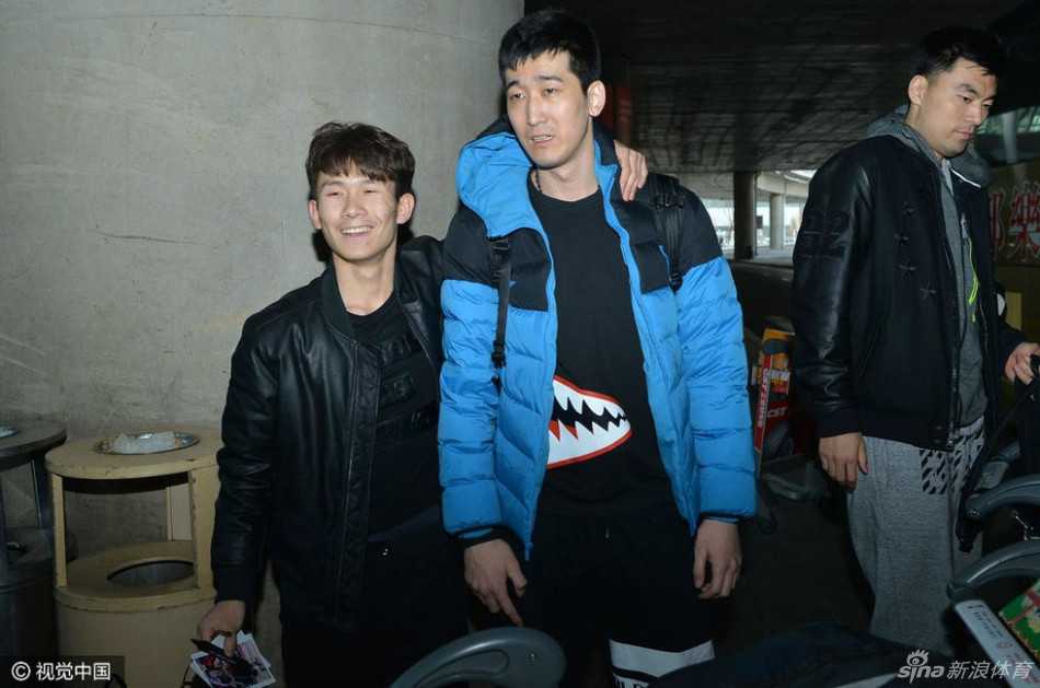 接机现场人声鼎沸，球迷们高举着“无论成败 与辽同在”的标语牌，眼神热切地望向出口方向，他们的脸上写满了对英雄归来的期盼与骄傲。