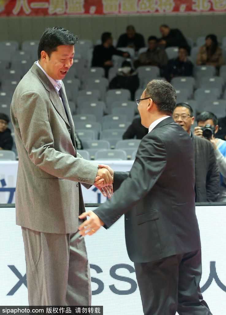 昔日八一五虎甬城再聚首,范斌与王治郅场边细数峥嵘岁月 镜头拉近,捕捉到了两人交谈中最真挚的表情。范斌微微低头,眉头轻蹙,正对着大郅娓娓道来,仿佛在分享着执教福建队的心得与困惑。王治郅的面容依然俊朗温和,嘴角带着淡淡的笑意,耐心地聆听这位老大哥的诉说,两人周围仿佛形成了一个独立于喧嚣赛场之外的安静世界。