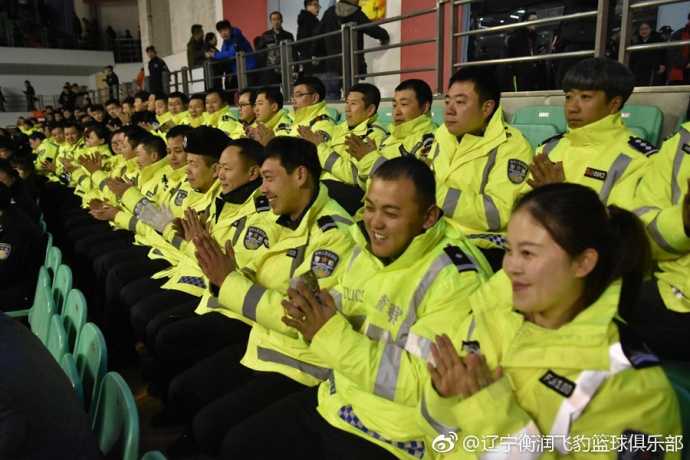 全国特级优秀人民警察关吉文作为公安干警代表获邀观赛，他身穿警服端坐于看台，神情专注而欣慰，胸前勋章在体育馆灯光下微微闪烁