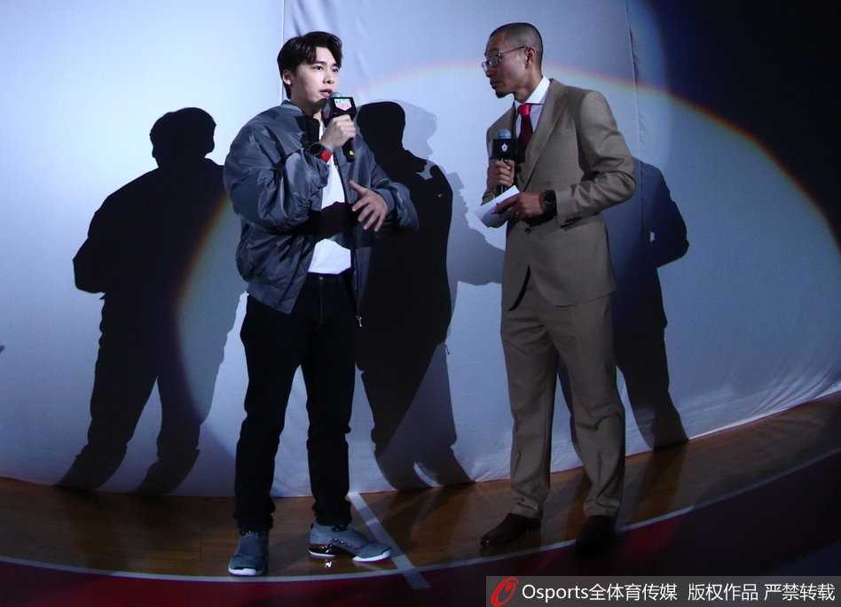 丁彦雨航持球面对防守，眼神坚毅准备突破，身旁的李易峰在观众席起身为其加油