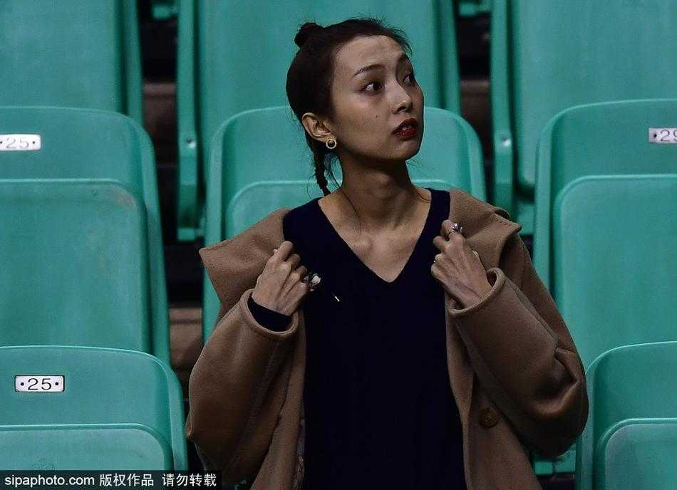 李晓旭的爱妻身穿时尚冬装，提前数小时抵达本溪主场，眼神中充满期待与关切，安静地坐在看台上等待比赛开始。