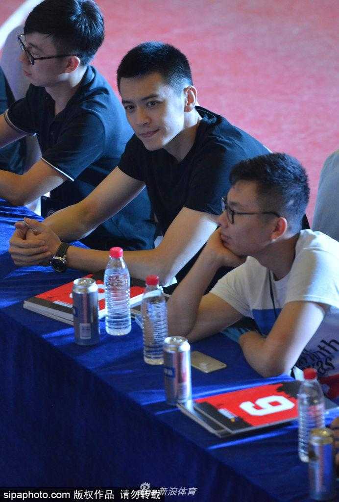 活动现场，杨鸣侧身倾听主持人提问，阳光洒在他棱角分明的侧脸上，他微微低头，嘴角挂着谦逊而温暖的笑意，举手投足间尽显辽篮队长从容不迫的成熟魅力。