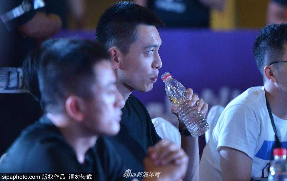 沈阳夏日午后，杨鸣现身三人篮球赛场，他面带标志性的微笑，眼神专注地看着场上球员的对抗，一身简约休闲装难掩其俊朗气质，仿佛一缕清风拂过喧嚣的球场。