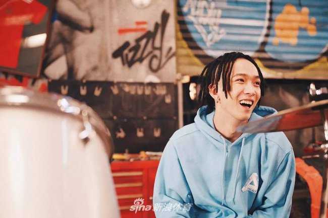 欧阳靖在充满街头感的场景中做出经典手势，背景的涂鸦色彩张扬，他脚上的Yeezy 350 Boost 