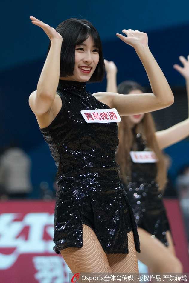 热舞间隙，一位篮球宝贝转身回眸，额前的发丝被汗水微微打湿，眼神中却透露出专注与坚定，展现了啦啦队员在激情表演背后的敬业精神。