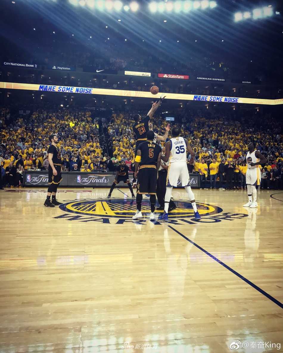 赛场边的秦奋正与友人交流，他戴着时尚的墨镜和棒球帽，面带微笑，轻松惬意，背景是热闹的球迷看台，仿佛将场边的奢华看球体验定格在了这一刻。