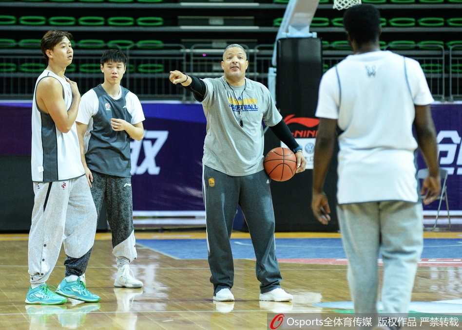 王非亲自下场，身体微蹲，认真地给天津队大外援霍尔曼讲解内线防守的站位技巧。