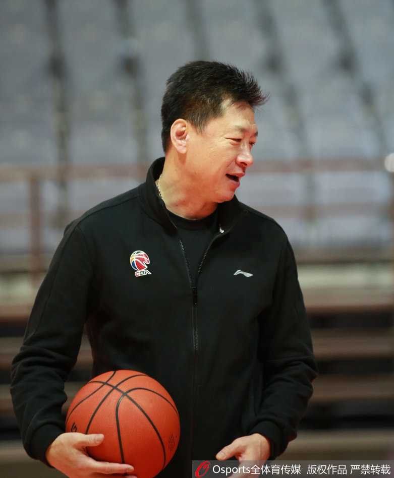 李春江双手放在背后，神情专注地盯着场上队员的跑位，仿佛在思考下一局的攻防策略。