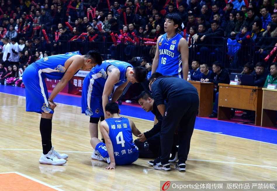 史鸿飞在队友和队医的搀扶下缓缓起身，他低垂着头，无法独立行走，身体的重量完全依靠身边人的支撑。