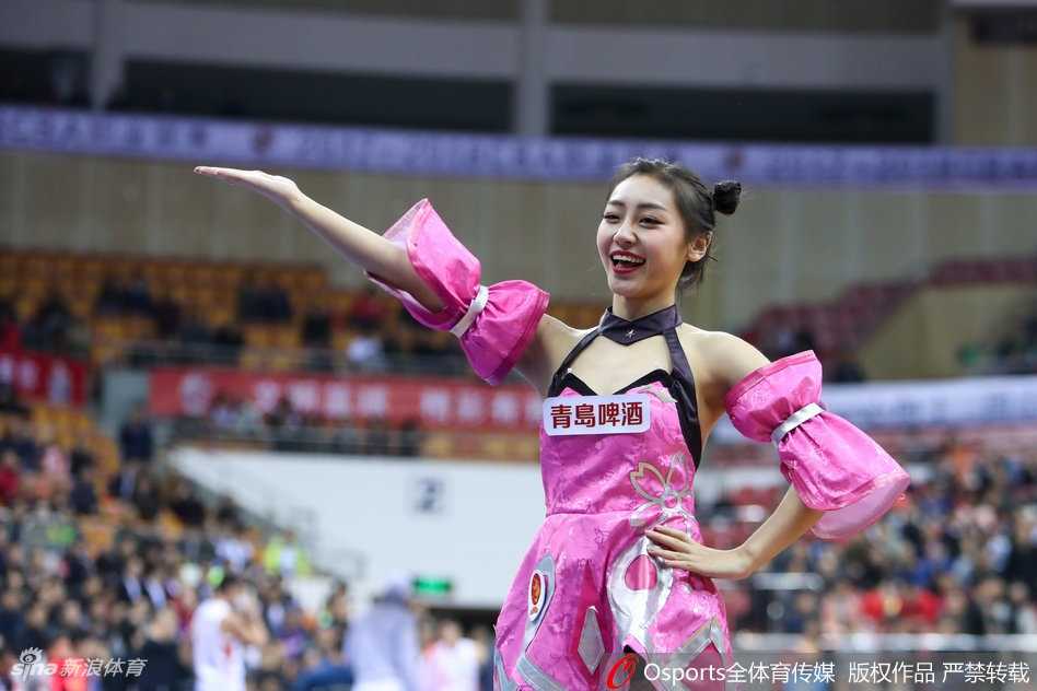 两名队员背靠背摆出弓箭步，裙摆飞扬露出修长双腿，手中的花球在灯光下流光溢彩，仿佛乾坤圈旋转生风