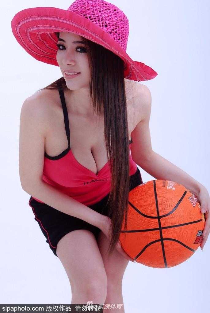 袁颖芬坐在篮球场馆地板上，双腿交叉，双手抱膝，侧脸轮廓精致如雕塑，氛围宁静而美好