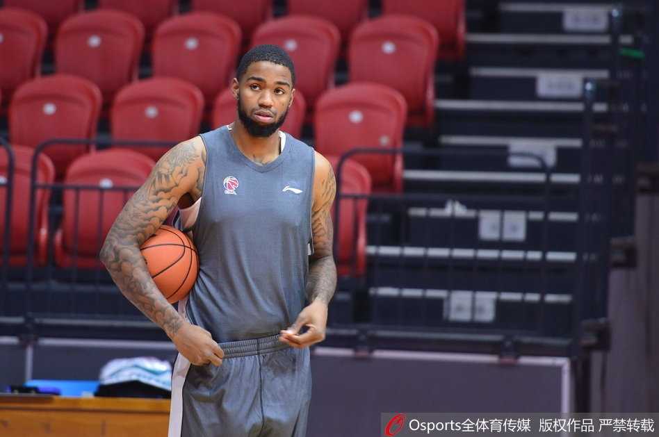 肖恩朗在新疆队训练馆里双手大力灌篮，肌肉线条分明，落地后眼神坚毅盯着篮筐，仿佛要把憋着的劲全使出来