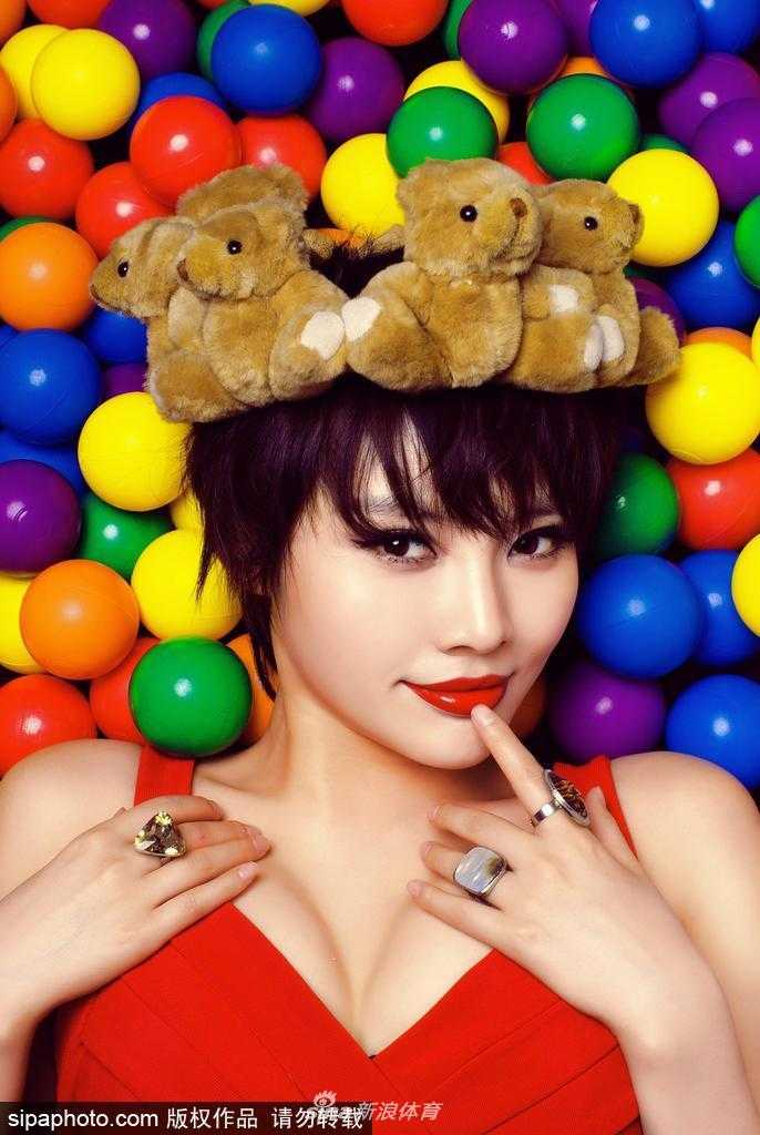 阳光下，她身着紧身运动装，手托篮球轻抚秀发，腰肢纤细，展现出健康迷人的身体曲线