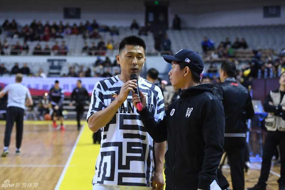 肯帝亚队长易立弯下腰，面带微笑地与坐在椅子上的小男孩轩轩亲切互动，轩轩穿着特制的小球衣，眼神中充满期待与喜悦。