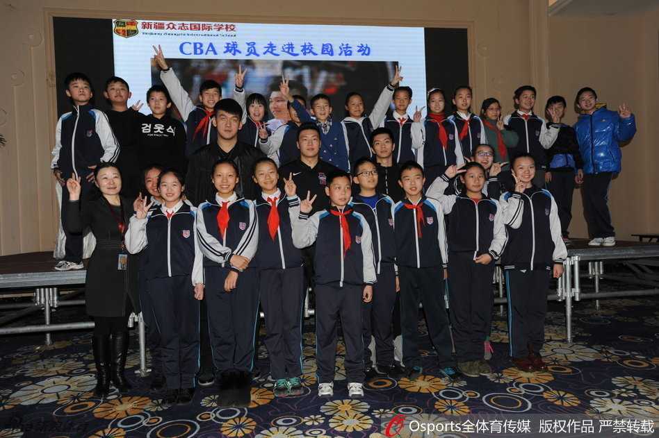 李根坐在椅子上，身体微微前倾，正专注地为排队的孩子们一一签名。他的身后，是安静的校园走廊，而他的面前，是一条长长的队伍，每一张递过来的纸上，都写满了对未来的期许。