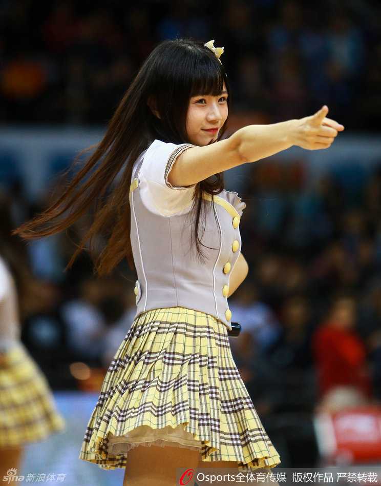 候场区里，女孩们相互整理着衣领和头发，专注的眼神中透露出对这次表演的重视，她们要把最完美的一面献给现场的篮球迷。