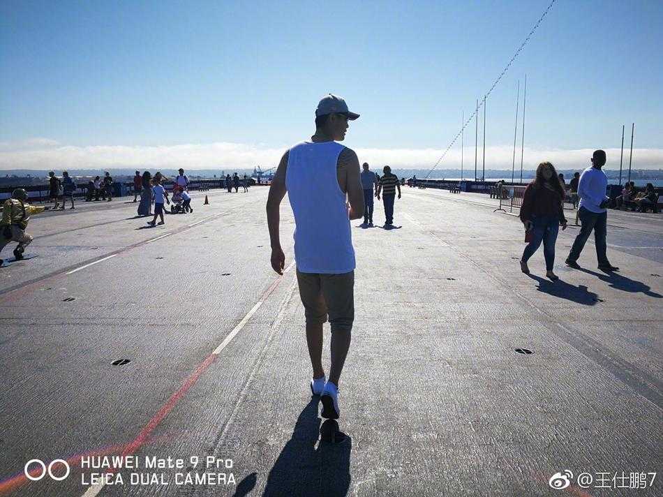 在巴尔博亚公园的莉莉池畔，王仕鹏以远处的植物园和金色拱门为背景，脸上带着轻松愉悦的笑容，记录下这个完美的午后时光。