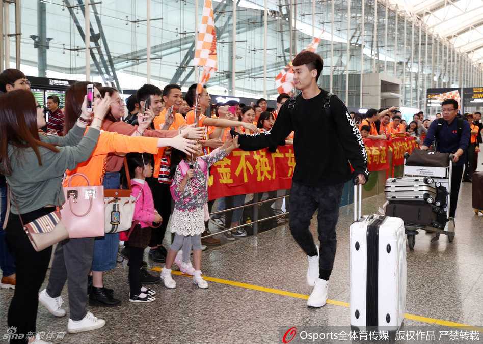 身穿黑色训练服的周鹏面带笑意，主动伸出右手与护栏旁伸来的球迷手掌用力击掌，气氛热烈而和谐。