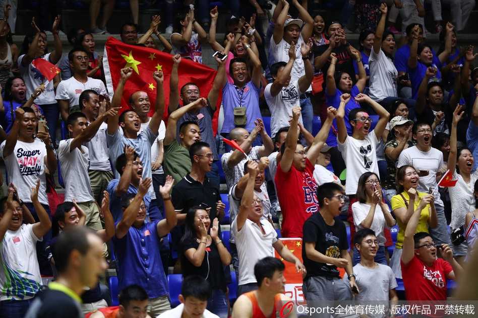 一位可爱的小球迷手拿国旗，眼神天真无邪，笑容温暖人心