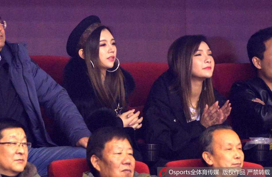 丁彦雨航的女友坐在看台上，长发披肩，气质温婉。在周围喧嚣的球迷中，她显得格外安静，双手轻握置于膝上，眼神中带着一丝期待与紧张，静静等待着那个身披山东队战袍的少年英雄登场。