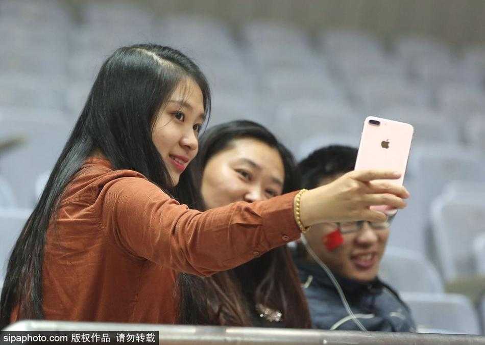 看台上的一位女球迷面对镜头露出了甜美的微笑，她的笑容如同冬日里的一抹暖阳，或许是因为支持的球队有了出色的发挥，又或许只是因为沉浸在现场的篮球氛围中，这份喜悦感染了周围的人。