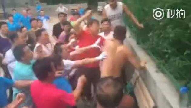 篮球场上的夕阳红与青春火,一场场地之争背后的城市之问 一名光着上身的年轻人在球场边被数名老人团团围住,手臂被拉扯,冲突一触即发,气氛紧张至极。