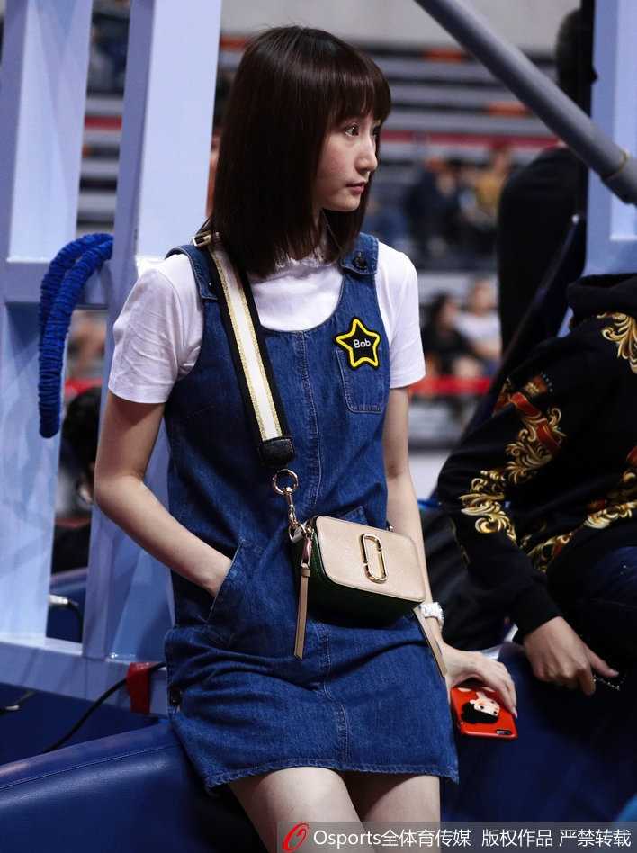 篮球场边的最美风景:周鹏妻子刘美见证“粤川战”的柔情时刻 镜头拉近,刘美的侧颜精致立体,微微扬起的下巴带着一丝骄傲。她静静地坐在那里,仿佛能给予场上拼搏的丈夫无形的力量,牛仔裙的剪裁完美勾勒出她的优雅身姿。