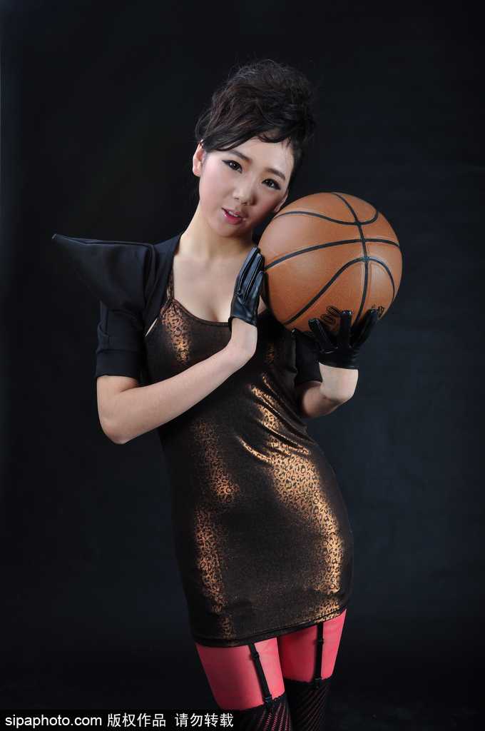 篮球宝贝与全息投影篮球互动，她轻轻托起虚拟的发光篮球，姿态舒展，未来感十足的装备让她如同掌控时空的少女。