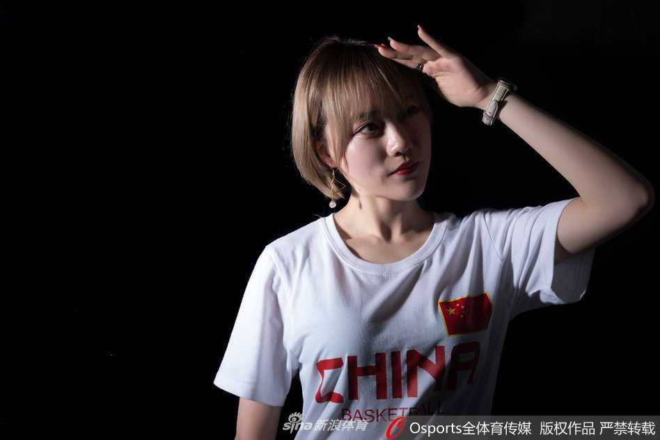 阳光下，篮球宝贝的秀发随风飘扬，她单手控球，脸上洋溢着自信的笑容，那股为男篮助威的真诚感染力穿透画面直达人心。