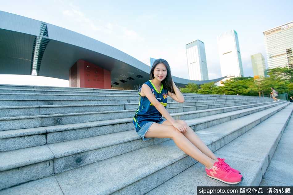 篮球宝贝们身穿统一白色加油服，面对镜头露出灿烂笑容，修长的美腿在灯光下格外抢眼，充满了青春的朝气与活力。