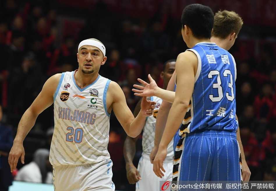 新疆队小外援达柳斯-亚当斯如闪电般突破北京队的双层防线，他眼神坚毅，在两人夹击的缝隙中寻找上篮的机会。