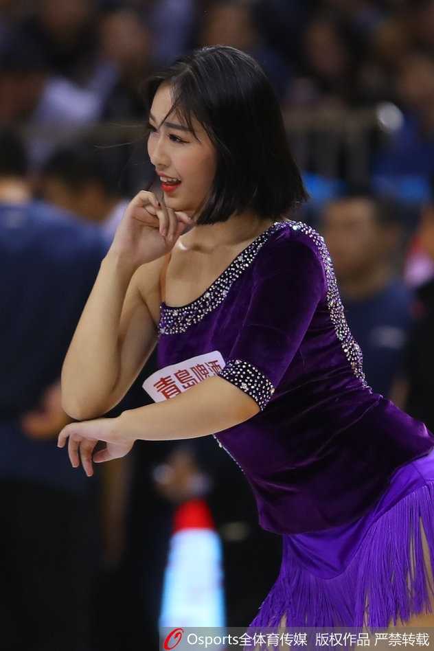 在明亮的赛场灯光下，两位篮球宝贝背对背摆出酷炫的造型。她们身着闪亮的表演服，配合着现场动感的音乐，展现出力量与美感的完美结合。