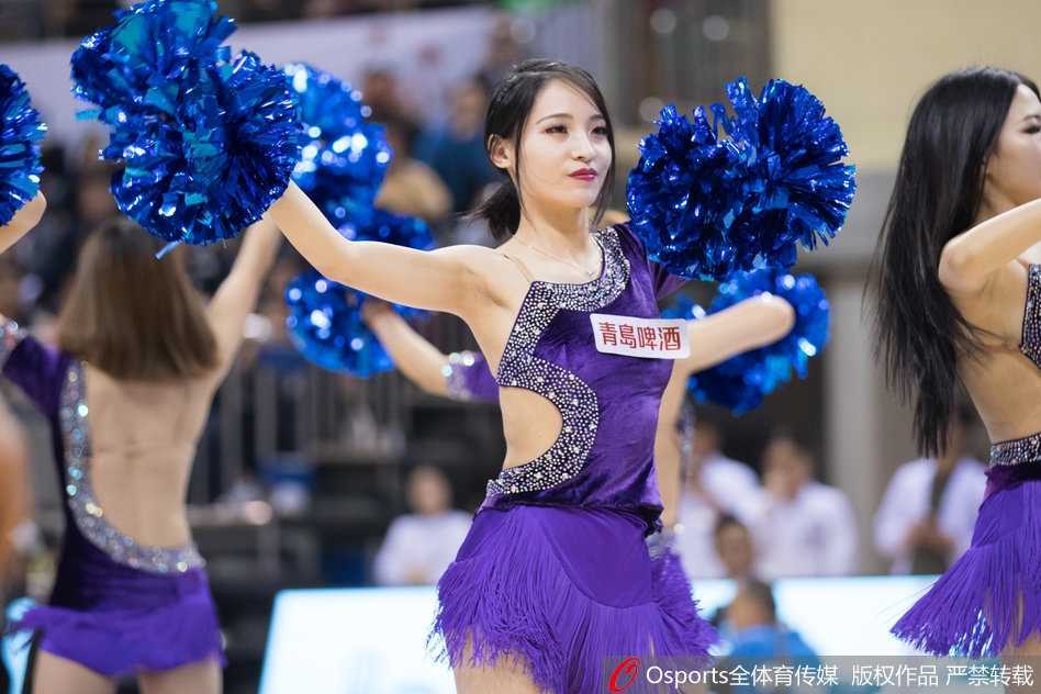 一名篮球宝贝正在聚精会神地进行舞蹈表演，她手中的花球随着动感的节奏在空中飞舞，飞扬的发丝和专注的表情，定格了她在赛场上最美的瞬间。